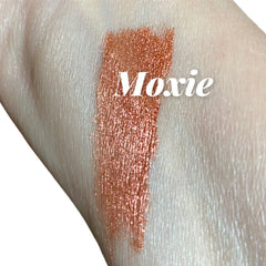 Moxie shimmer swatch, copper metallic color, applied on skin, brand name visible