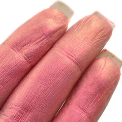 Close-up of fingertips applying iridescent multi-chrome eyeshadow with shimmering color shift effect on eyelid