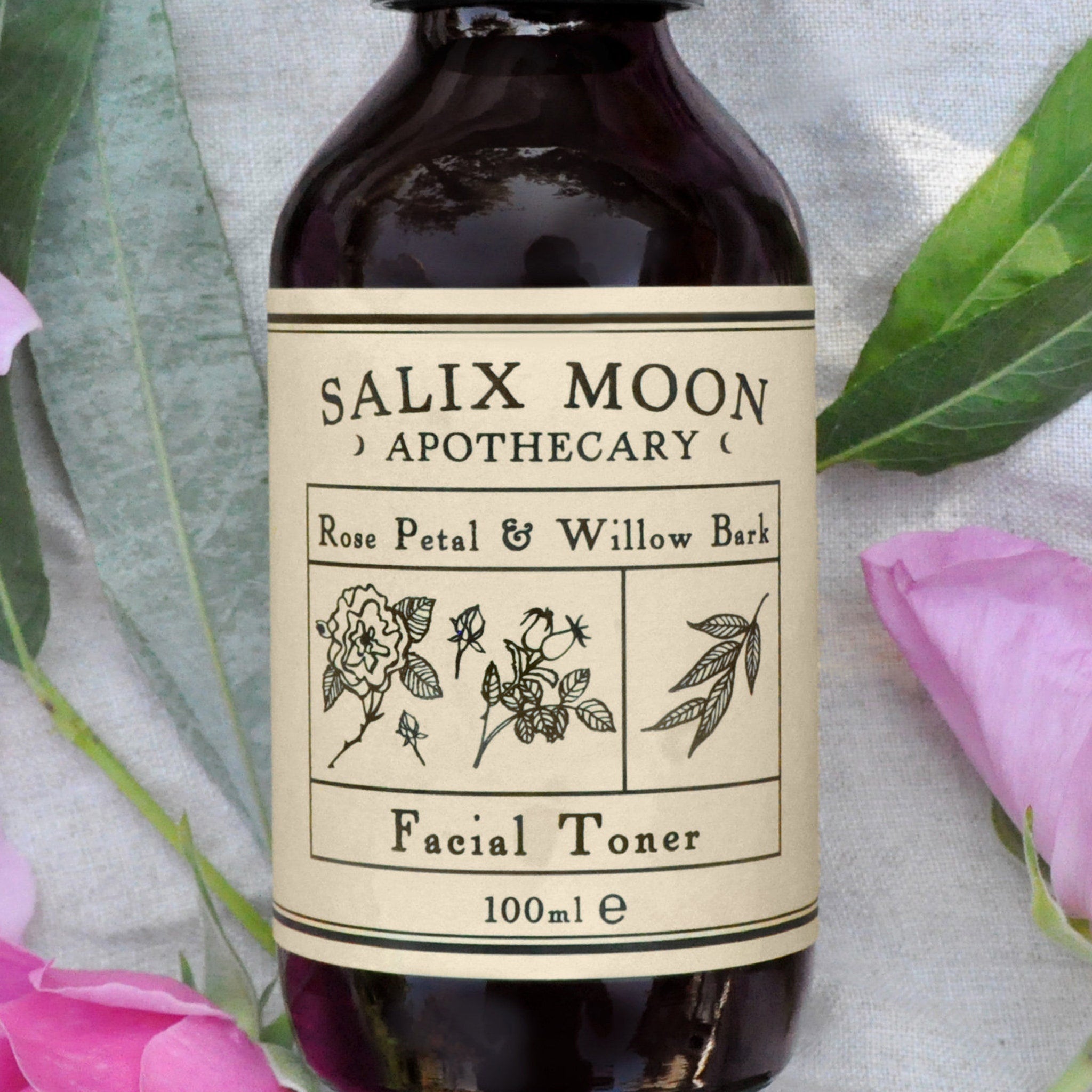 Facial toner bottle, dark glass, cream label, Salix Moon Apothecary, floral illustration
