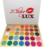 Eyeshadow palette with multiple colors, gold tray, and 2Chique Boutique text