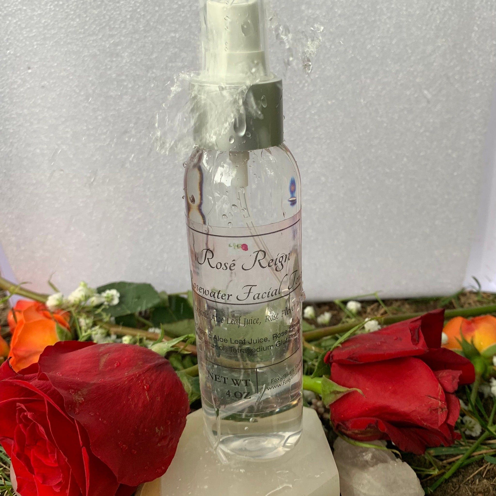 Rosewater toner spray bottle, clear glass, white spray, Rose Reign label visible