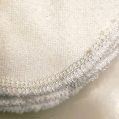 Round white fabric with stitched edge detail, close-up view
