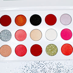 Hand applying shimmery bronze eyeshadow from palette to eyelid with blending brush