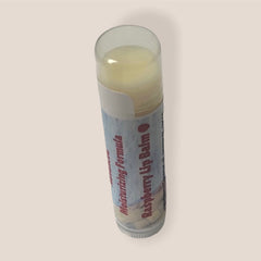 Raspberry lip balm with clear cap, white and blue label, Rock Island Naturals text visible