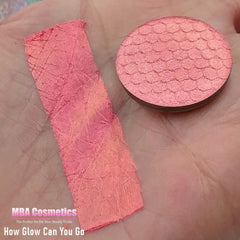 Close-up of multi-chrome eyeshadow pan showing iridescent color shift from purple to green with metallic finish