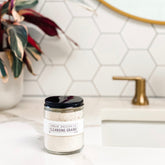 Cleansing grains in a glass jar with a black lid, white label, and light-colored grains