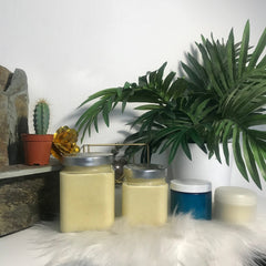 Cream jars with silver lids, yellow cream, and blue and white containers on white fur