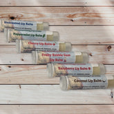 Lip balm tubes in clear plastic with flavor labels, arranged on wood surface