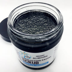 Activated charcoal exfoliating facial scrub in a black jar with a clear glass rim and a black lid, Punta Coco brand