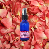 Rose Hydrosol blue glass bottle with black sprayer and Bear's Beauty label on rose petals