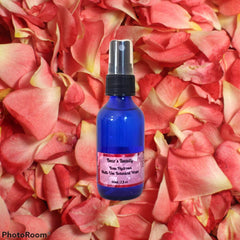 Toner bottle on rose petals, blue glass bottle, black spray top, Bear's Beauty label