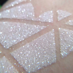 Close-up of vegan white eyeshadow with icy sparkling shimmer in compact palette