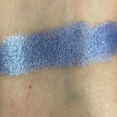 Close-up of fingertips applying shimmery peach eyeshadow from the Smiley palette to eyelid crease