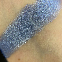 Close-up of vibrant matte and shimmer eyeshadows in a rainbow palette with embossed smiley face designs