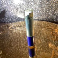 Pen with silver and blue sections, clear top, and gold label with text visible