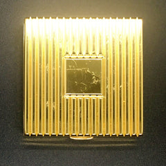 Gold compact with vertical ribbed pattern and rectangular center detail