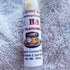 Lip balm tube with white label, Earl Grey tea illustration, and text on a white towel background
