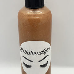 Close-up of fine mist spraying from sleek black makeup setting bottle with gold accents