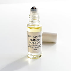 Cuticle oil roll-on bottle, clear glass, silver cap, Nomad label visible