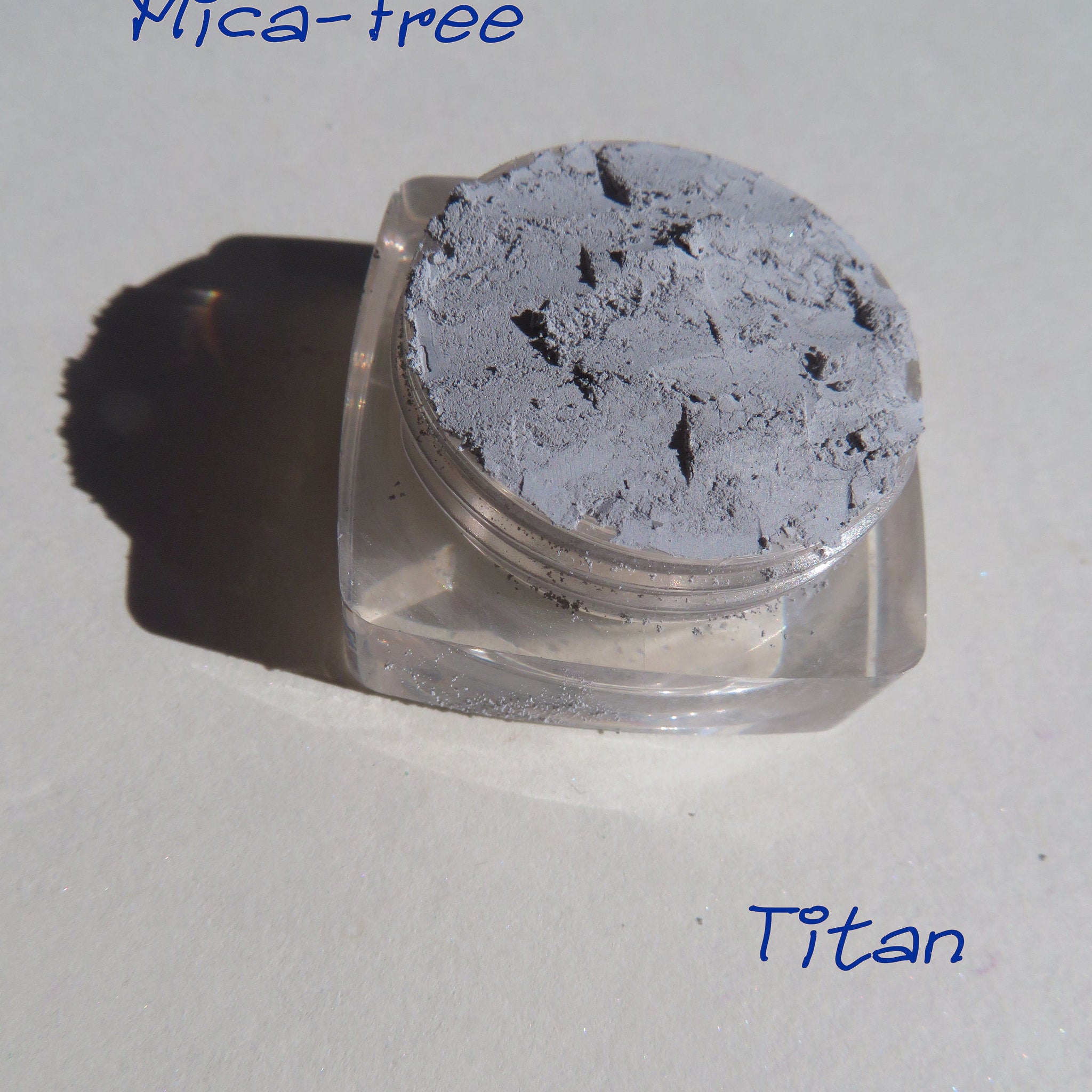 Matte gray loose pigment eyeshadow in a small jar with black lid, vegan mineral makeup with smooth powder texture