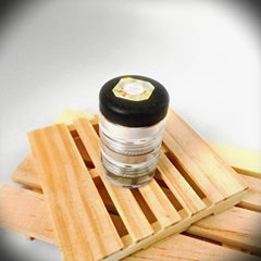 Side view of four travel-size eyeshadows and blushes in round compacts with mirrored lids, showcasing product thickness