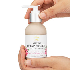 Microdermabrasion facial paste bottle, beige and silver pump, held in hands with label visible