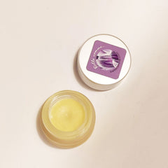 Lip balm in clear glass jar with yellow balm and Belle comme logo on lid