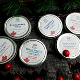 Body balms in silver tins with text, Bubble Republic brand on gray sweater background
