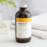 Organic face wash, brown glass bottle with silver cap, Conscious Skincare label visible