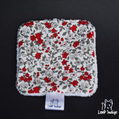 Floral print fabric square with red, white, and gray flowers, white trim, and "Loup Indigö" brand label
