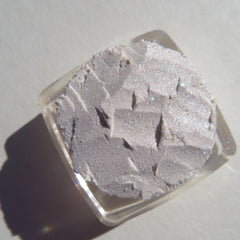 Glitter eyeshadow, light grey, textured, in a clear square container