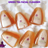 Green tea facial cleanser bottles with white pump, orange liquid, and KaziRokz label