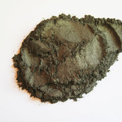 Close-up of tarnished mineral eye shadow showing shimmering bronze and taupe flecks in compact pan