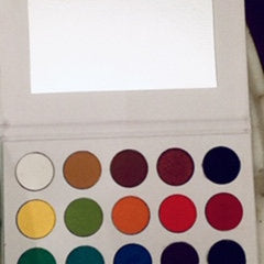 Eyeshadow palette with multiple colors, white case, and mirror inside