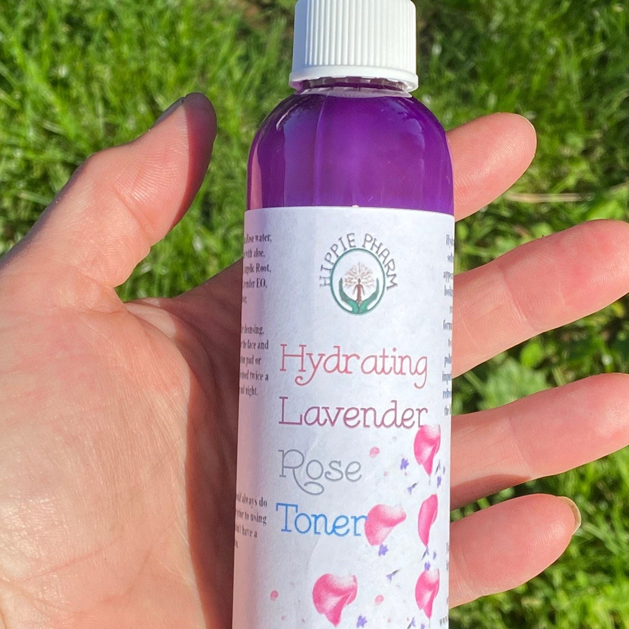 Facial toner bottle with purple liquid, white cap, and Hippie Pharm label held in hand