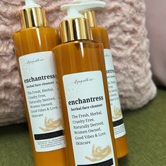 Facial cleanser bottles, amber liquid, gold pump, Enchantress label on white