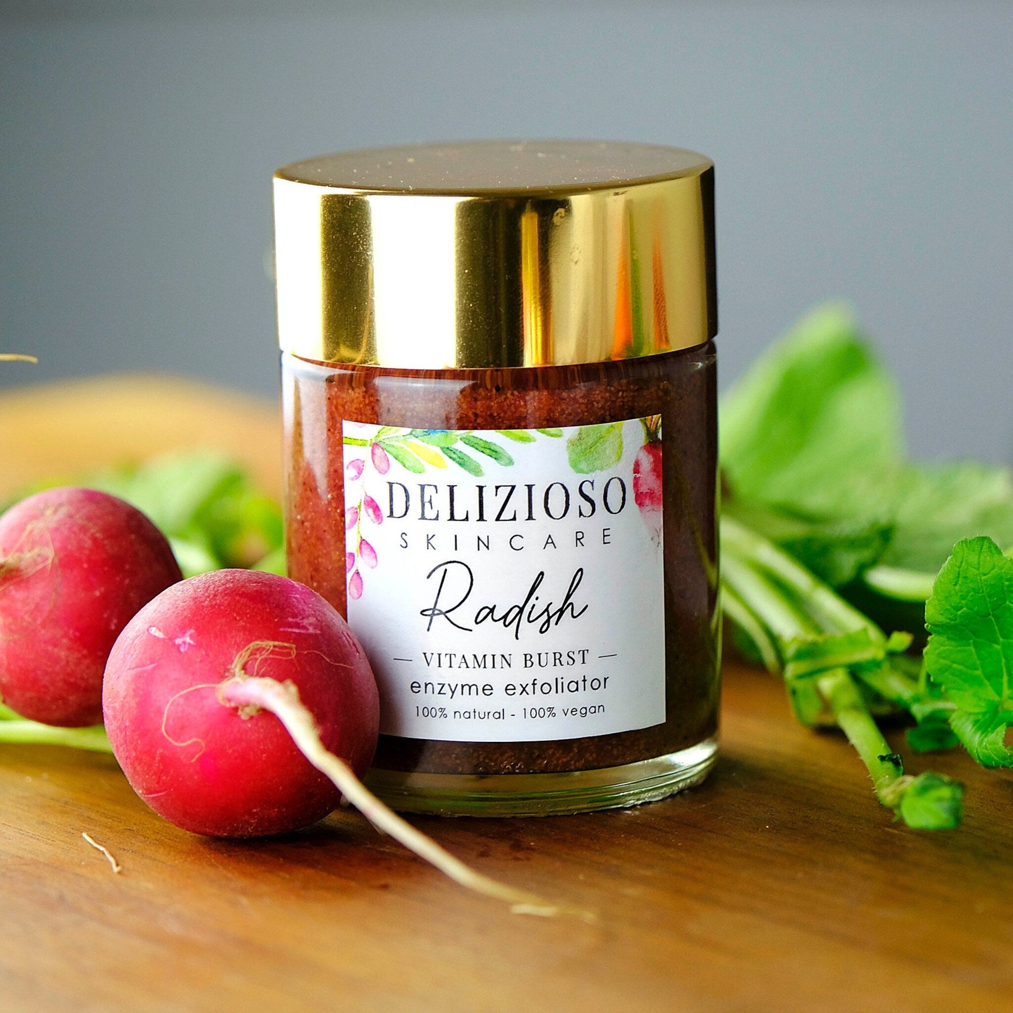Face scrub jar with gold lid, glass jar, and red radish on wood surface
