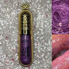 Lip gloss with purple glitter, gold tube, and glossy lips application