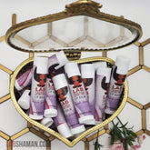 Lip balm tubes with white caps, purple label, in heart-shaped gold container, LAB SHAMAN visible