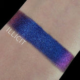 Eyeshadow swatch with blue to purple shifting color and glittery finish, "ILLICIT" text visible