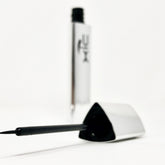 Liquid eyeliner, black applicator with fine tip, silver tube with XiC text visible