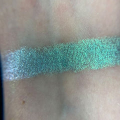 Close-up of shimmering teal and emerald green eye shadows in the Fairy Frog palette with intricate scale-like texture