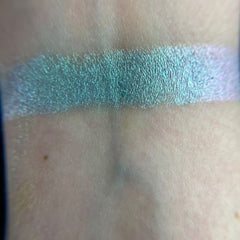 Close-up of fingertips applying shimmery teal eyeshadow from Fairy Frog palette onto eyelid