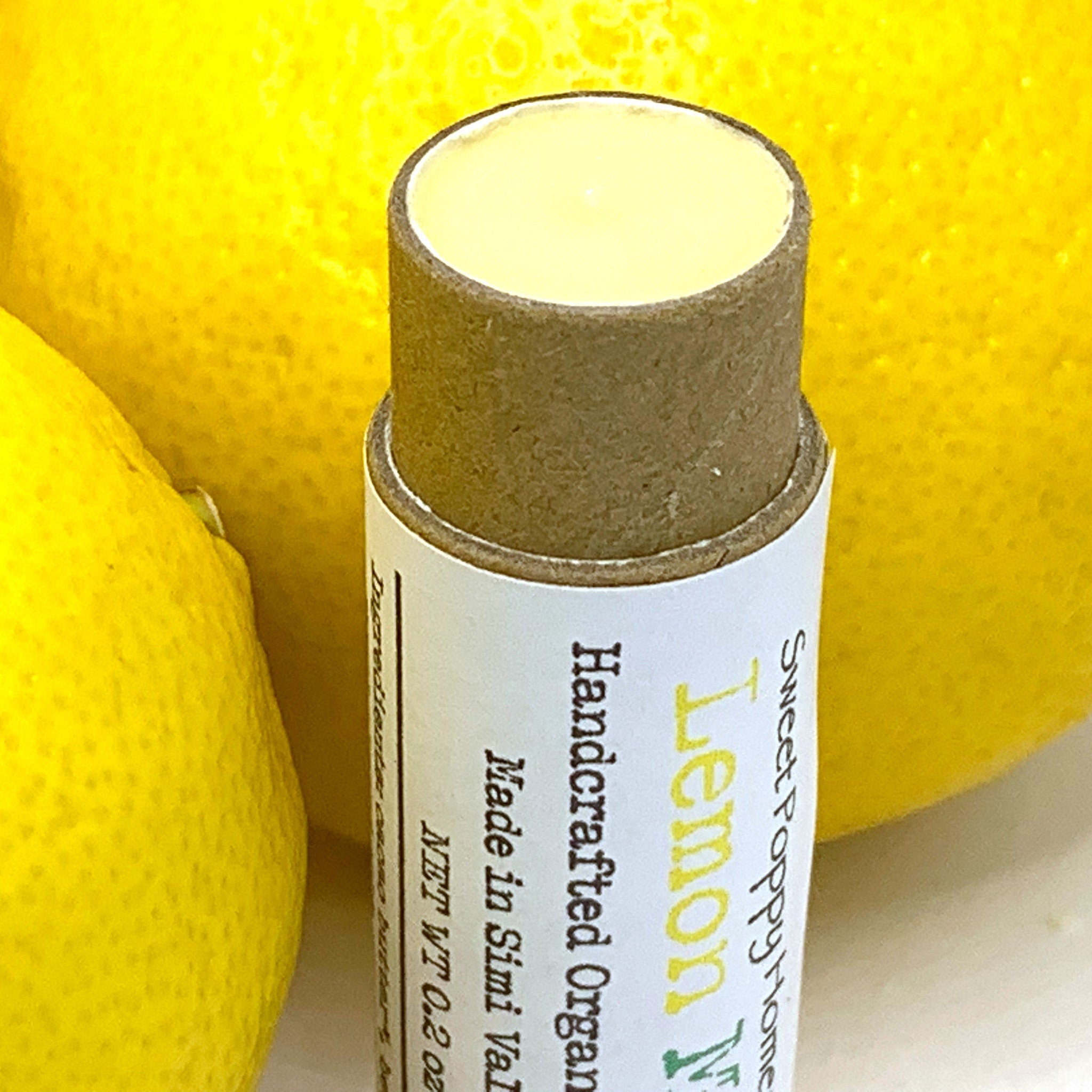 Lip balm tube with yellow balm, tan cardboard, and Sweet Poppy Homestead label
