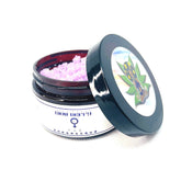 Sugar scrub jar with pink scrub, black lid, and Glow Berry label