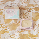 Eye shadow compact with pale gold color, pink frame, and Mary Kay branding visible
