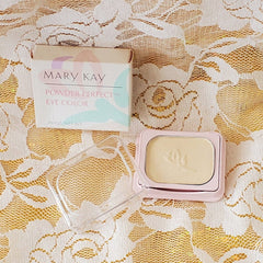 Eye shadow compact with pale gold color, pink frame, and Mary Kay branding visible