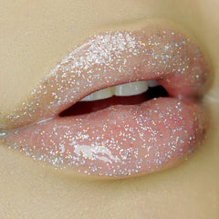 Lip gloss with silver glitter, pink color, and glossy finish on lips