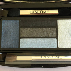 Side view of LANCÔME x Alber Elbaz eye shadow palette showcasing blue and taupe shades in sleek black packaging