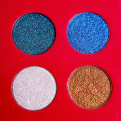 Eyeshadow palette with blue, gold, and white shimmer shades on red background